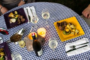 Outdoor dining table with gravy, wine, kebabs